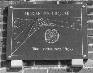 Figure 16 (left): One of a matched pair of dials above the entrance to the Bennett Building of Leicester University.  This on the left marks the time of day in 'seasonal' hours